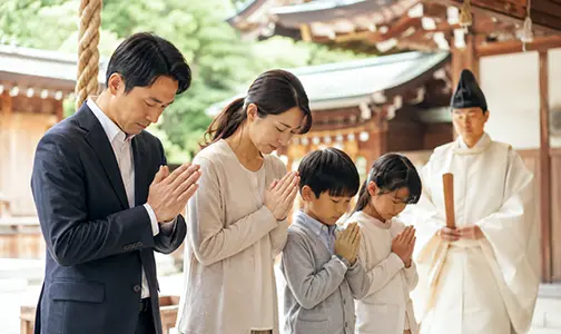 神職を前に社殿で祈る家族