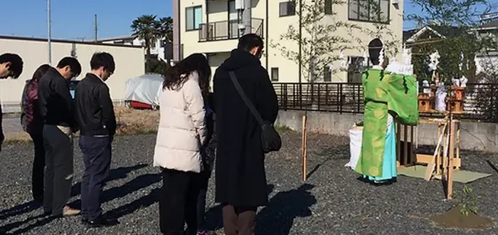 地鎮祭で参列者が神職とともに工事の安全を祈願している様子