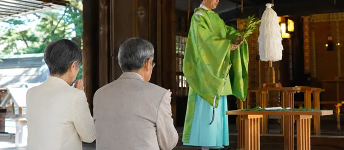 神前で祈りを捧げる夫婦