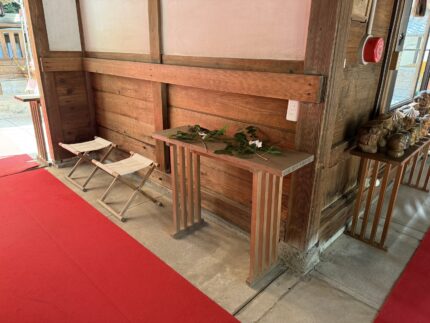 社殿の中の玉串案に玉串を供え、床几を並べた祭場